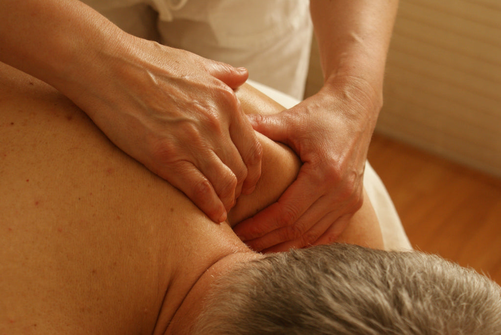 Woman lying face down and receiving a shoulder massage