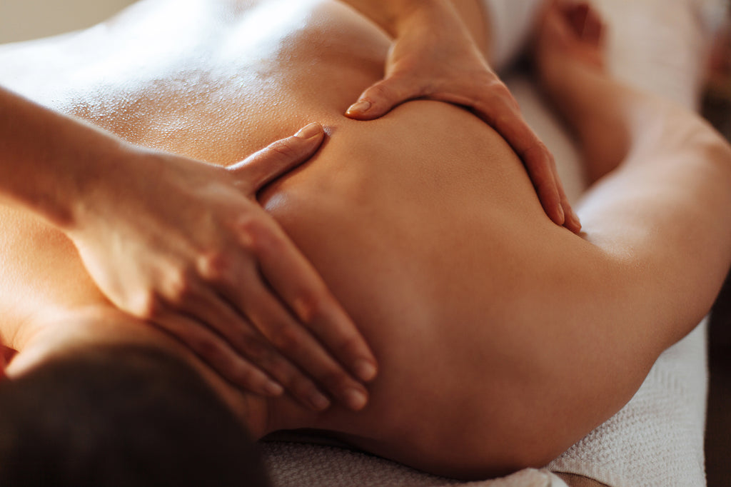 Man lying face down getting a massage on his shoulder