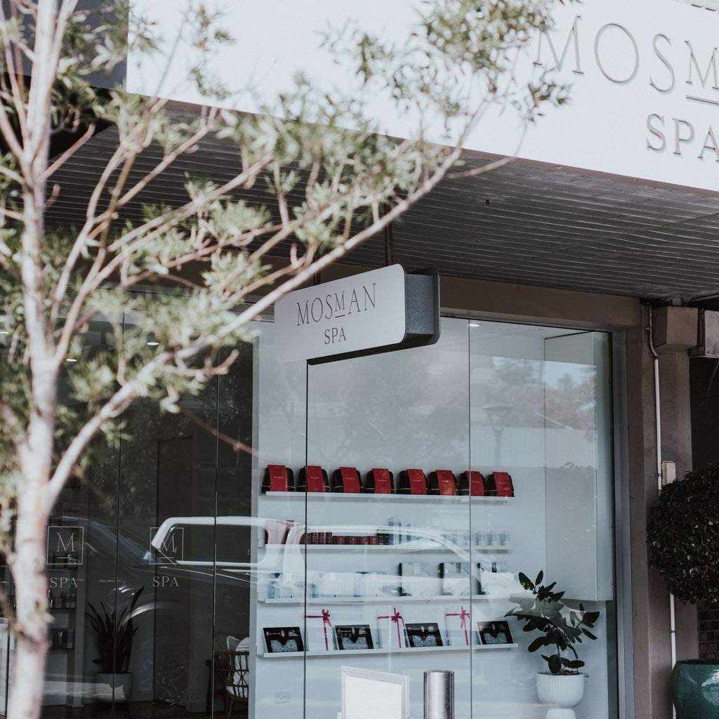 The entrance to Mosman Spa with the sign visible and a selection of products on display. Small tree in foreground. 