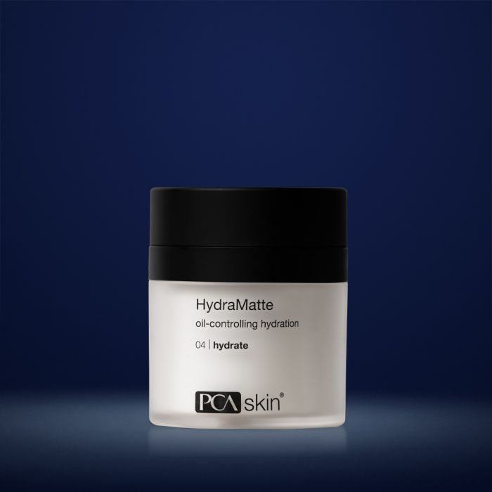 PCA Hydramatte in white container with black lid in front of a dark blue background