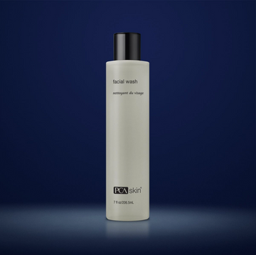 PCA Skin facial wash in off-white container with black lid in front of dark blue background