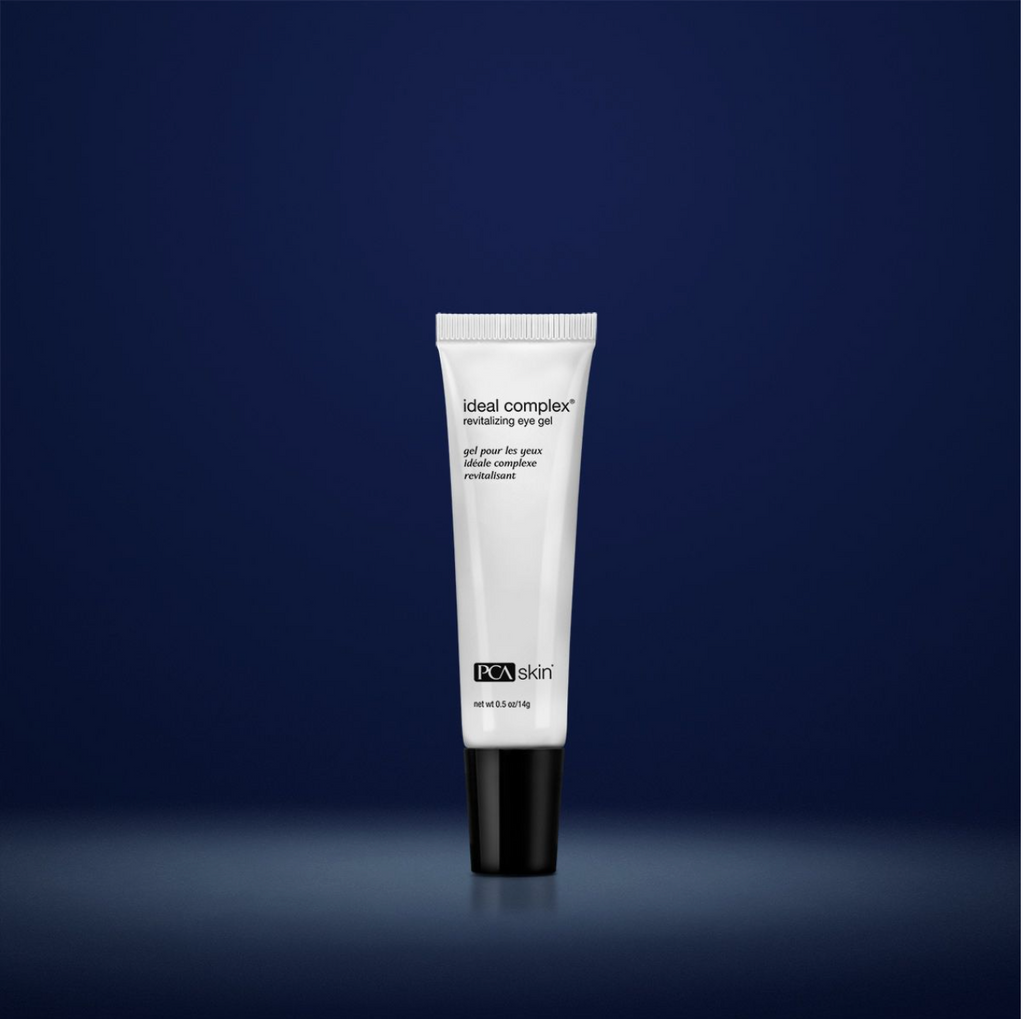 PCA Skin Ideal Complex revitalising eye gel in white container with black lid in front of dark blue background