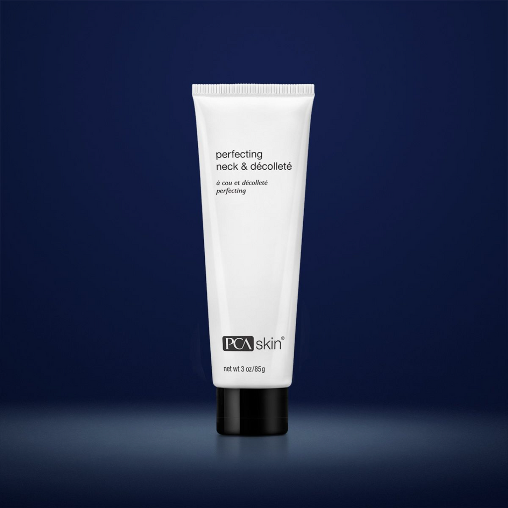 PCA Skin perfecting neck and decollete cream in white container with white lid in front of dark blue background