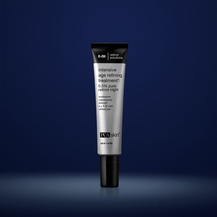 PCA Skin intensive age refining treatment in grey container with black lid in front of dark blue background