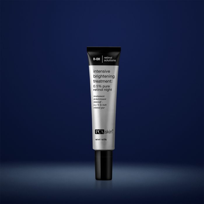 PCA Skin intensive brightening treatment in grey container with black lid in front of dark blue background
