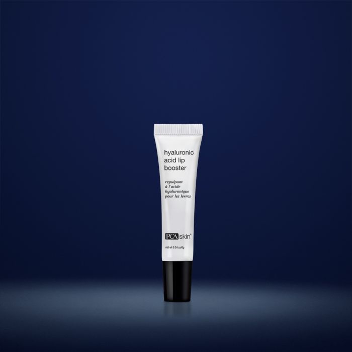 PCA Skin hyaluronic acid lip booster in white container with black lid in front of dark blue background